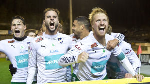 IFK Mariehamn firade i fjol – hur går det i dag? Jani Lyyski och IFK Mariehamn firar vid ett plakat.