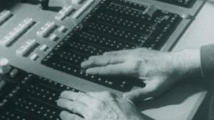 Äänitarkkailija Bengt Johanssonin kädet radiostudion äänipöydän ohjaimilla.