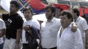 Serbimiehiä kävelemässä kadulla lippu mukanaan