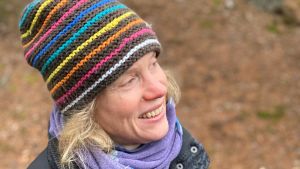 Susanne Österlund-Pötzsch är kontaktperson för Svenska litteratursällskapets frågelista om aktivism och samhällsengagemang. Susanne Österlund-Pötzsch i radig mössa mot en höstbrun bakgrund.