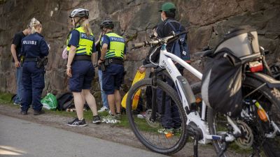 Cyklande poliser har stannat vid Sandudds badstrand för att prata med en skolavslutningsfirare.