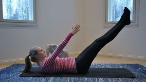 Nainen tekee pilatesliikettä matolla