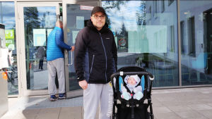 Vili Turpeinen och dottern Hilda. En man står bredvid en barnvagn med ett litet barn i.
