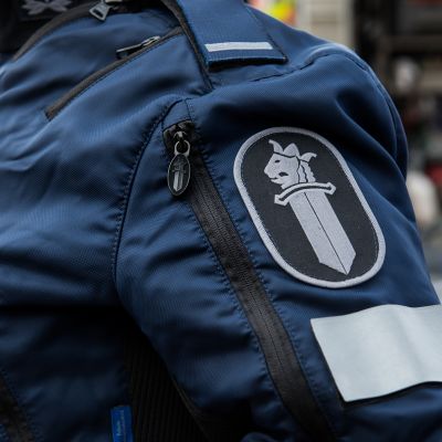 Poliisiin logo poliisi univormussa