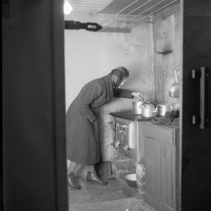  Kellarissa asuvan perheen äiti hellan ääressä (1956)