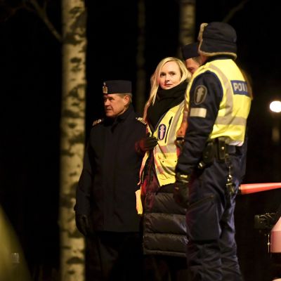 Keltaiseen poliisiliiviin pukeutunut Maria Ohisalo poliisin tarkistuspisteellä.