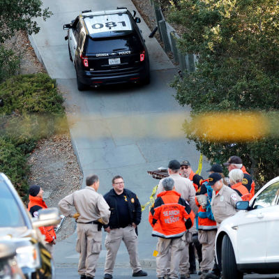 Polis står vid en backe vid polisbilar efter skjutning i Kalifornien.