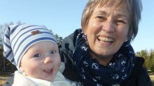 Astrid Packalén här tillsammans med barnbarnet Freddie, 5 månader. dam håller en liten baby i famnen