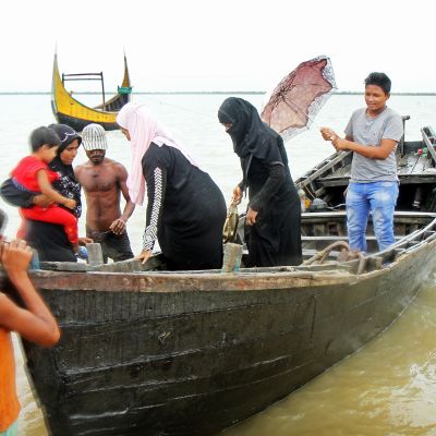 Rohingya-pakolaisia rantautumalla veneellä.