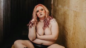 Evaleena Vuorenmaa har varit med om dåligt bemötande flera gånger i vården. Hon är själv är someaktivist och skriver om kroppspositivism på sin Instagram Kvinna med långt ljusrosa hår och bar överkropp, trosor och höga stövlar. Hon sitter med handen framför brösten och håller ena handen i håret.