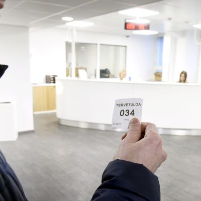 Mies jonottaa työvoimatoimistossa Helsingissä.