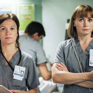Sykkeen kaksi sairaanhoitajaa seisovat ja katsovat jotakin.