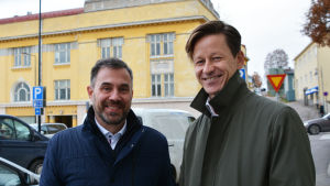 Biträdande stadsdirektör Fredrick von Schoultz och stadsplaneringschef Dan Mollgren är nöjda med planerna. Två män står utomhus framför ett gult hus.