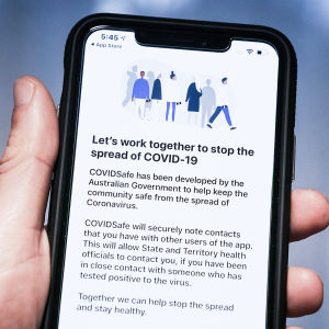 Bilden föreställer en mobiltelefon. På skärmen står det "Let's work together to stop the spread of covid-19".