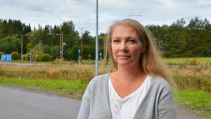 För Satu Wallenius är det praktiskt att ha hälsovårdstjänsterna nära. En blond kvinna står på en parkeringsplats. Bakom henne syns grönska och en väg.