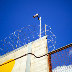 Kamera och taggtråd vid fängelse.