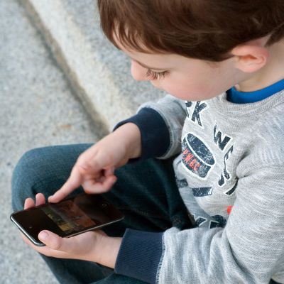 Lapsi käyttää mobiililaitetta.