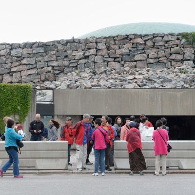 Turisteja ja betoniesteitä Temppeliaukion kirkon edustalla tiistaina 20. kesäkuuta