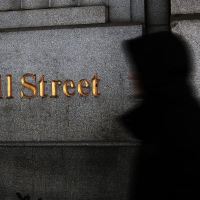 Mies kävelee wall street -kyltin ohi