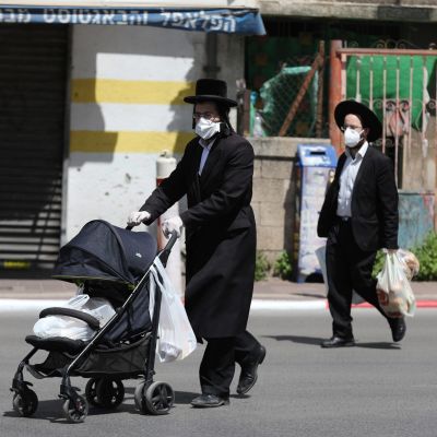 Suojamaskeihin pukeutuneita ultraortodoksisia miehiä Bnei Brakissa, Israelissa