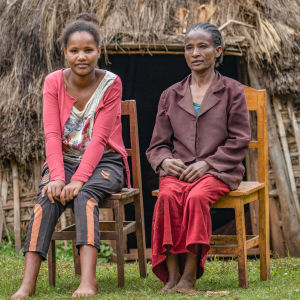 Nuori ja vanhempi etiopialainen nainen istuvat kotinsa edessä puutuoleilla.