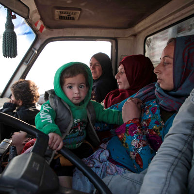 Tre syriska kvinnor och två barn i en bil.