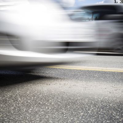 Kulunutta asfalttia ja liike-epäteräviä autoja.
