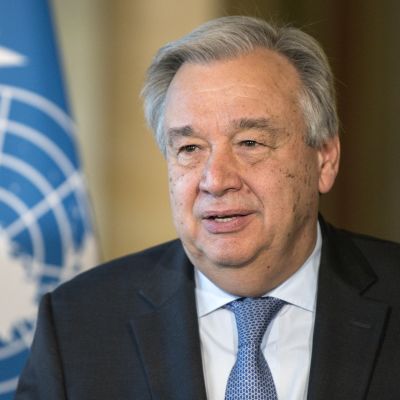 Antonio Guterres, taustalla YK:n lippu