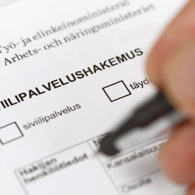 Henkilö täyttää siviilipalvelushakemusta.