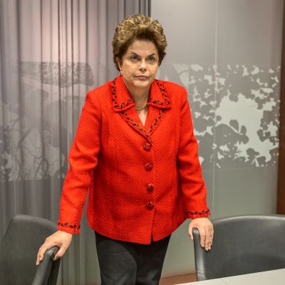 Dilma Rousseff nojaa seisoessaan kahteen tuoliin.