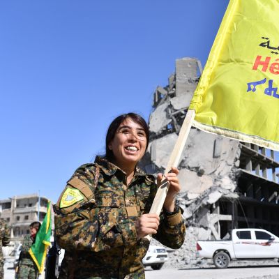 Syyrian demokraattisten joukojen (SDF) komentaja Rojda Felat kulkee lippua kantaen Raqqassa.