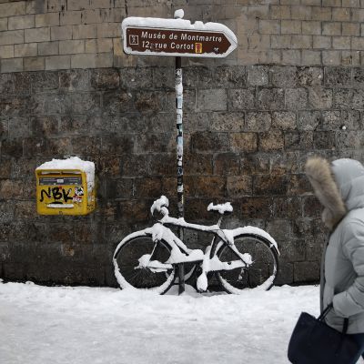 Jalankulkija lumisateessa Montmartrella.