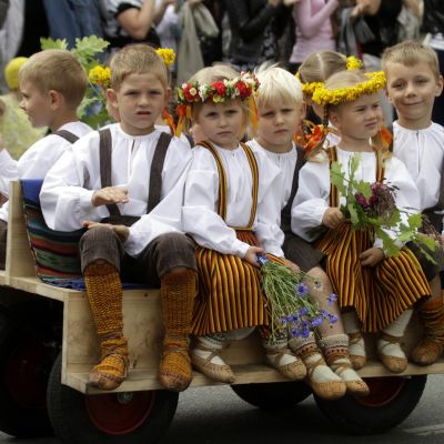 Lapsia kansallispuvuissa katujuhlassa.