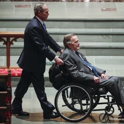 Yhdysvaltain entinen presidentti George W. Bush kuljettaa isäänsä myös entistä presidenttiä George Bushia pyörätuolissa äitinsä Barbara Bushin hautajaisissa.