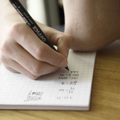 Nuori laskee matematiikan läksyjä.