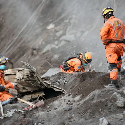 Vapaaehtoiset palomiehet etsivät tulivuorenpurkauksen uhreja Alotenangossa.