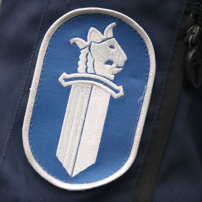 Poliisiin logo poliisi univormussa