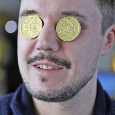 Bitcoin -kolikot miehen silmien päällä.