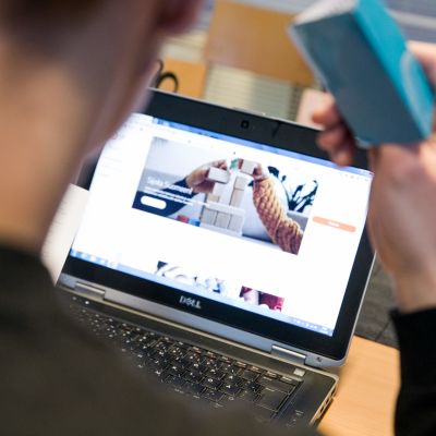 Mies selaa verkkopankkia avainlukulista kädessään.