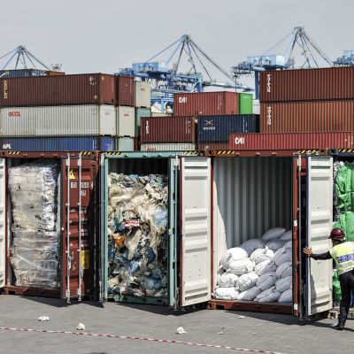 Poliisiviranomaiset tarkastavat muovijätekonttien sisällöt ennen alkuperäismaahan takaisin lähettämistä Port Klangin satamassa Malesiassa 28. toukokuuta.