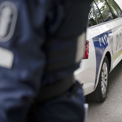 Poliisi ja poliisiauto.