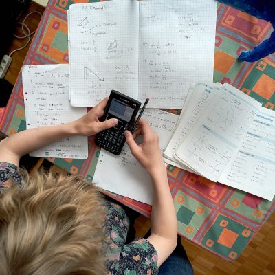 Koululainen tekee matematiikan tehtäviä.