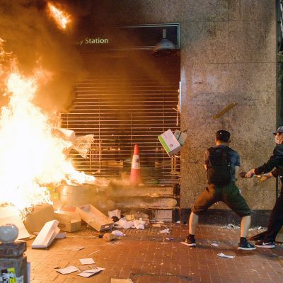 Mielenosoittajat polttavat tavaroita kadulla Hongkongissa.