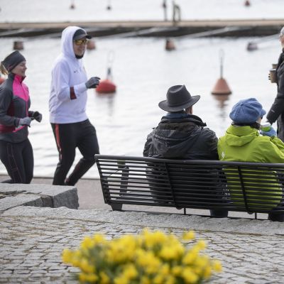ihmisiä ulkoilemassa Kaivopuiston rannassa