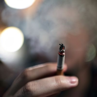 Mies polttaa tupakkaa kahvilassa.