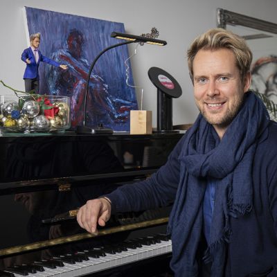 Oopperalaulaja Waltteri Torikka istuu pianon äärellä.
