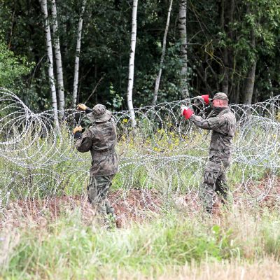 Puolalaiset rajavartijat asettavat piikkilankaestettä Valko-Venäjän vastaisella rajalla.