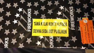 Gul dekal med texten "Tämä kylki kohti yleisöä - Denna sida mot publiken".