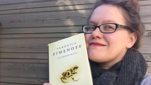 Kirjabloggaaja Reeta Törrönen pitää kädessään Veronica Pimenoffin romaania.