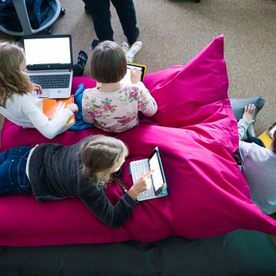 Lapsia tyynyn päällä tietokoneiden kanssa.